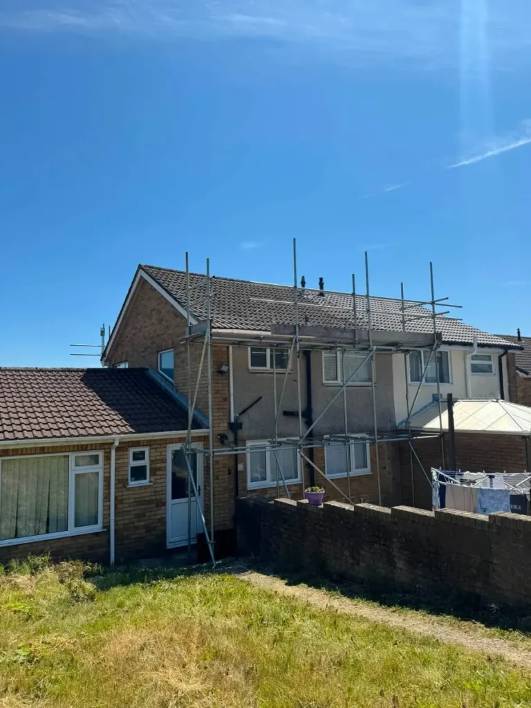 Scaffold edge protection with guardrails along the roof edge of a house